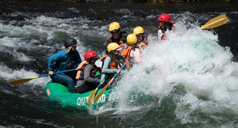 a group of gap year students paddle a raft through whitewater on an outward bound semester expedition 